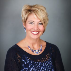 Catherine Falkner, M.D., a blonde woman wearing a black knit sweater with a sky blue top underneath.