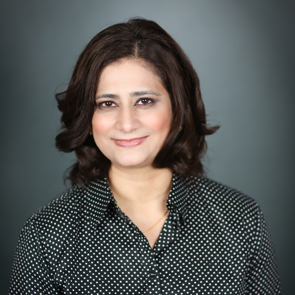 Afshan Samad, M.D., a brunette woman wearing a black and white polka-dot shirt.
